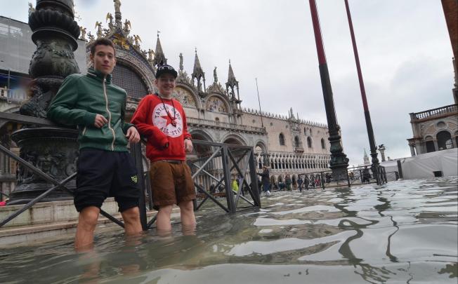 People stand in the flooded streets of Venice, November 1, 2012. Photo: EPA