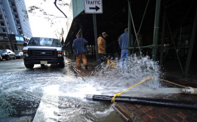 Workers continue to pump flood waters from a building, caused by Hurricane Sandy in New York on Friday. Photo: EPA
