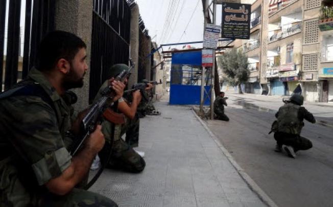 Syrian army soldiers taking position during a patrol in Harasta area eastern Damascus in Syria. Photo: EPA