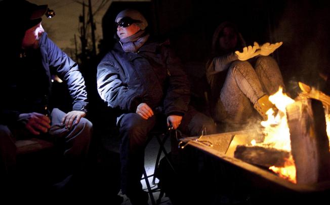 Residents in the Rockaway neighbourhood of Queens keep warm by lighting a fire in the street after their homes were damaged by superstorm Sandy. Photo: AFP