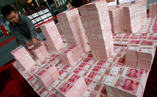 An artist uses 100-yuan notes to build a model. The currency was trading strongly yesterday. Photo: AFP