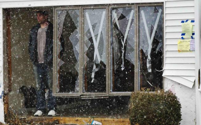 A homeowner in Lindenhurst, New York, watches the arrival of the early winter storm. Photo: Reuters