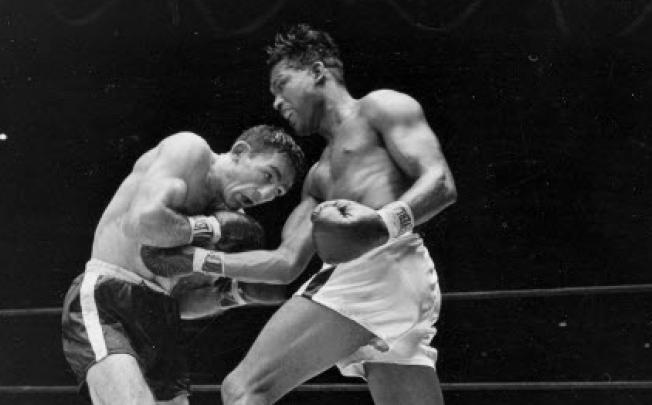 world middleweight champion Sugar Ray Robinson, right, fighting challenger Carmen Basilio (left) in 1957. Basilio has died aged 85. Photo: AP 