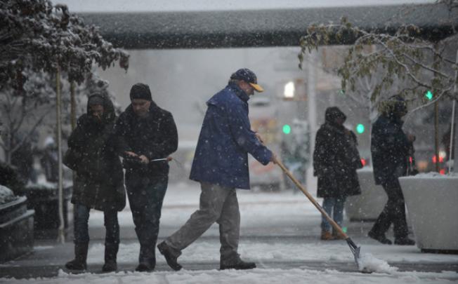 A man shovels snow from a sidewalk on Fifth Avenue in New York as a strong winter storm hits the northeast on Wednesday. Photo: AFP