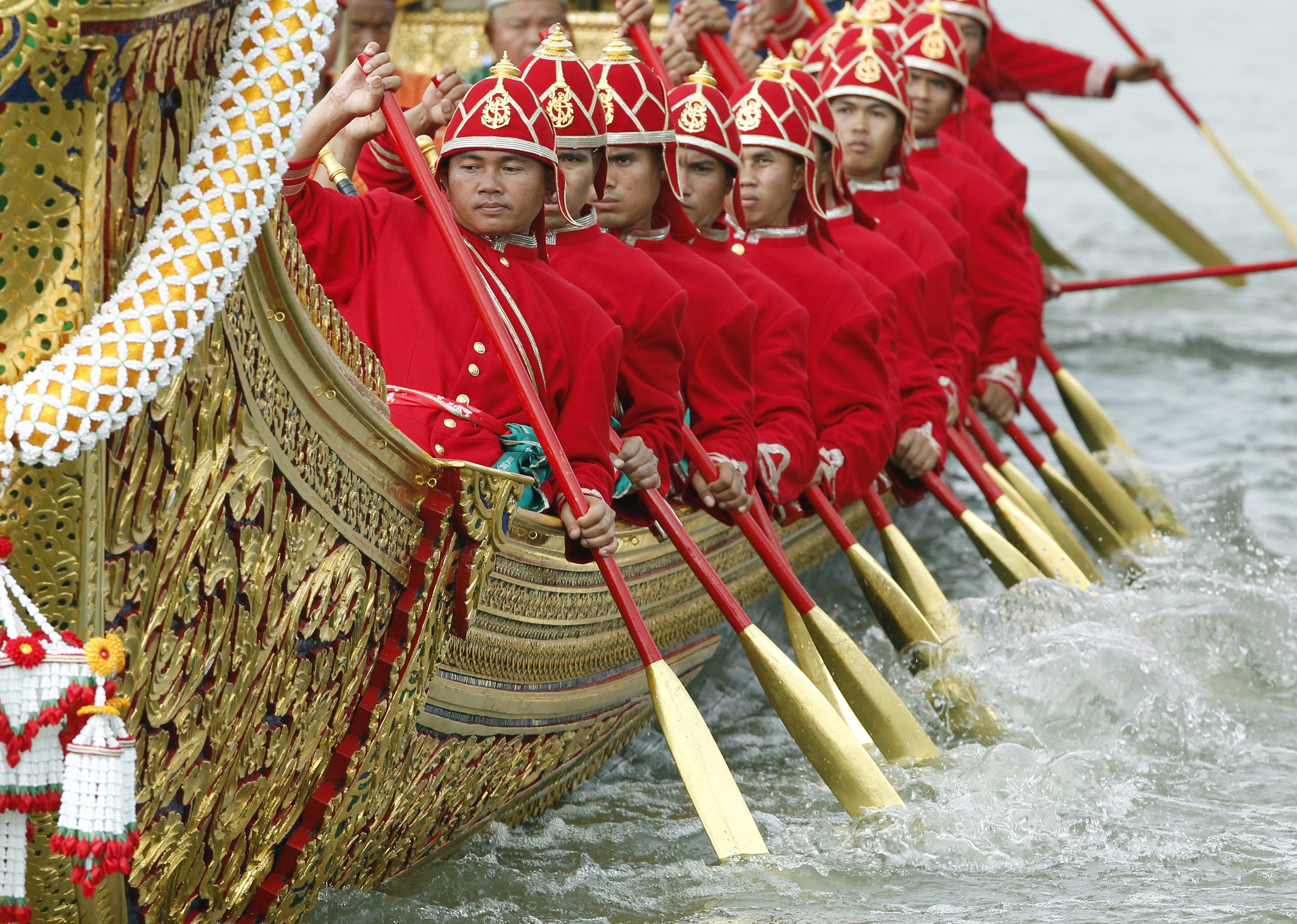 Thai Royal Navy oarsmen in ancient warrior costumes row in the royal barge procession on the Chao Phraya River in Bangkok on Friday. Photo: EPA