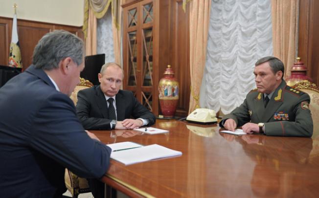 Defence Minister Sergei Shoigu (left), President Vladimir Putin and Colonel General Valery Gerasimov (right) meet in Moscow's Kremlin on Friday. Photo: AP