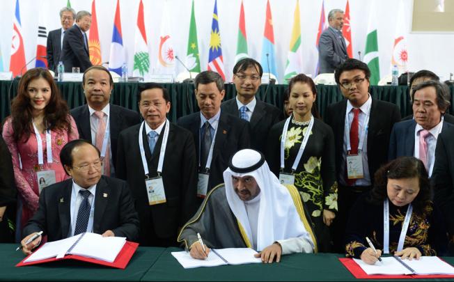 President of OCA Sheikh Ahmad (front centre) signs an agreement with the delegates of Vietnam during the OCA's general assembly.