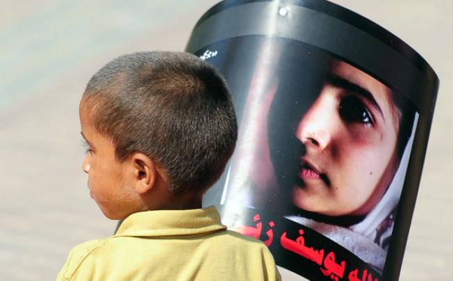 A Pakistani boy carries a photograph of child activist Malala Yousafzai to mark 'Malala Day' in Karachi on Saturday. Photo: AFP