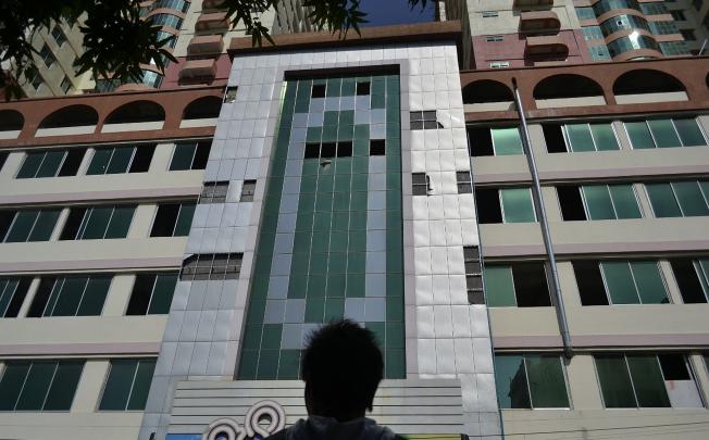 A man looks at the facade of Mandalay's highest building, the 25-storey Mann Myanmar Plaza, from where several window panes are missing after they fell following a 6.8-magnitude quake. Photo: AFP