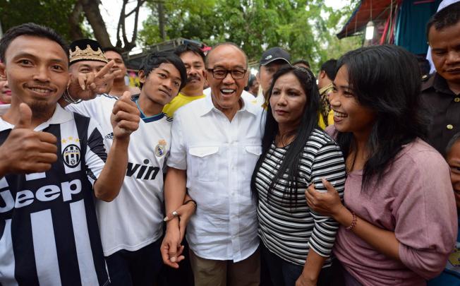 Chief of Indonesia's Golkar Party and tycoon Aburizal Bakrie (centre) meets voters in Jakarta. Photo: AFP