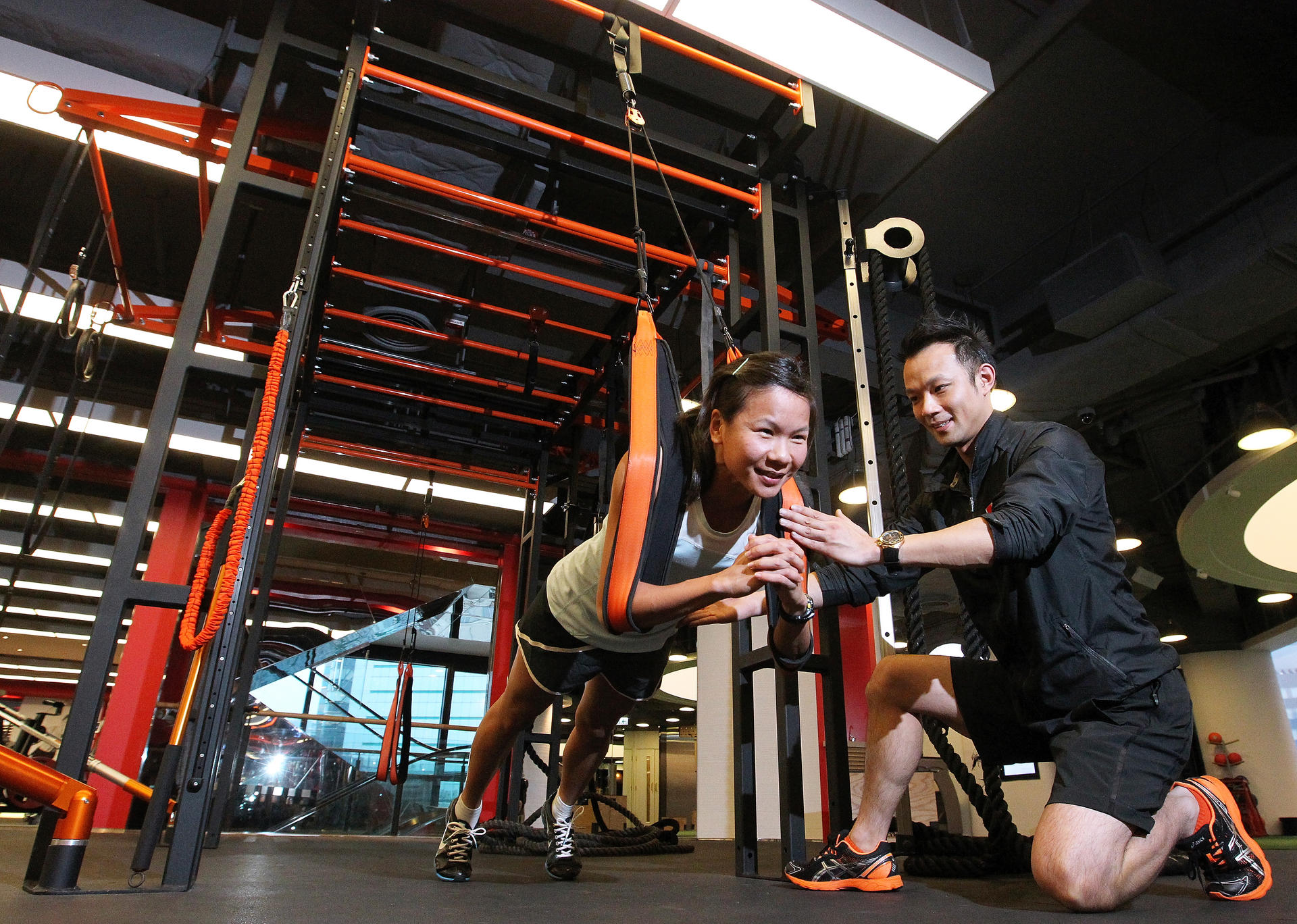 Personal trainer Alan Pak puts health editor Jeanette Wang through her paces with the PurMotion functional training equipment. The system uses ropes to train the body through a series of movements. Photos: May Tse