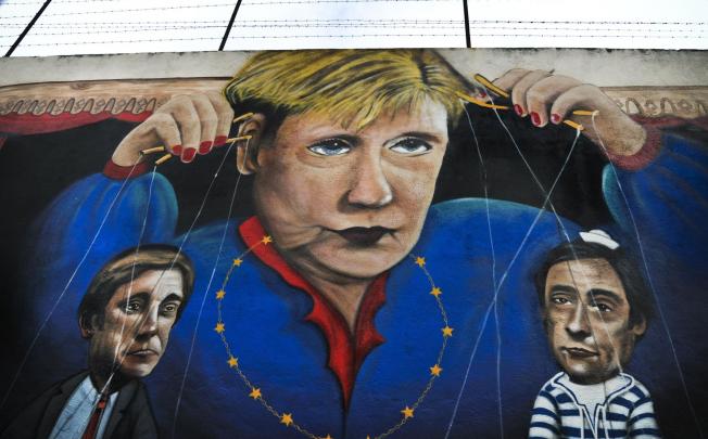 Graffiti depicting Angela Merkel as a puppet master. Photo: AFP