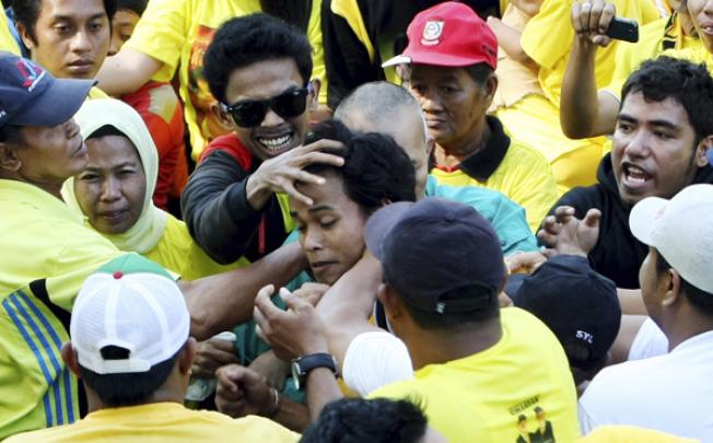 Suspected militant Awaluddin Nasir (centre) is beaten by the crowd after he threw a bomb at South Sulawesi Governor Syahrul Yasin Limpo on Sunday. Photo: AP