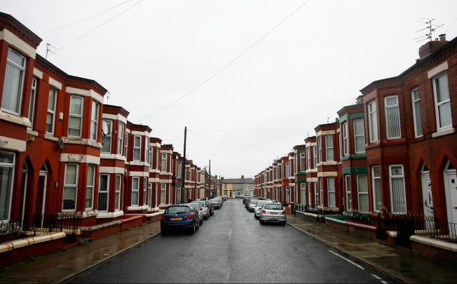 Vehicles sit parked outside a row of terraced houses in Liverpool, U.K., on Feb. 24, 2012. Photo: Bloomberg
