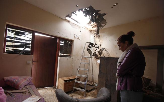 A Jewish woman surveys her damaged home in Sderot. Photo: Reuters