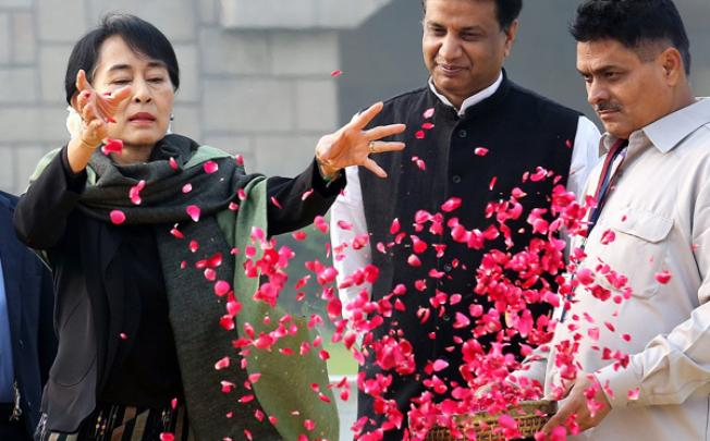 Myanmar opposition leader Aung San Suu Kyi sprinkles petals as she pays tribute at the Mahatma Gandhi memorial at Rajghat in New Delhi on Wednesday. Photo: EPA 
