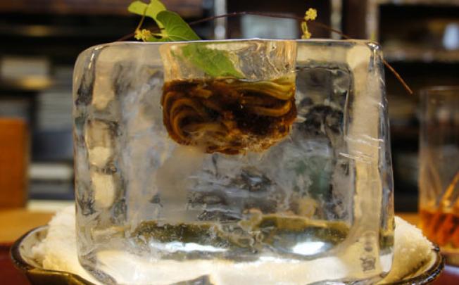 Cold buckwheat noodles with braised herring inside a huge ice cube , served at Tempura Matsu in Kyoto.