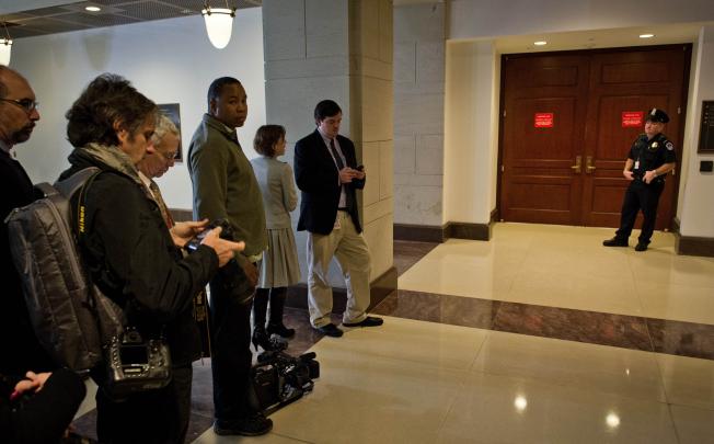 Reporters wait outside the "Restricted Access-Secure Room" as the House Intelligence Committee conducts a hearing on Benghazi with testimony by former CIA director David Petreaus. Photo: AFP