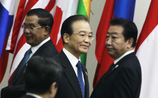 China's Premier Wen Jiabao (centre) walks between Cambodia's Prime Minister Hun Sen (left) and Japan's Prime Minister Yoshihiko Noda at the Asean summit in Phnom Penh on Sunday. Photo: EPA