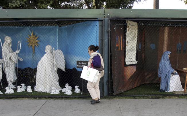 A woman walks past Christian displays in the Santa Monica park. Photo: AP