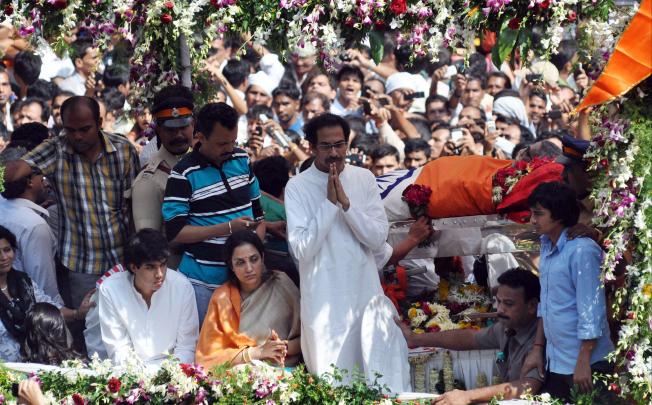Son of India's Hindu extremist leader Bal Thackeray, Uddhav Thackeray, centre, gestures to the supporters during his father's funeral in Mumbai. Photo: Xinhua