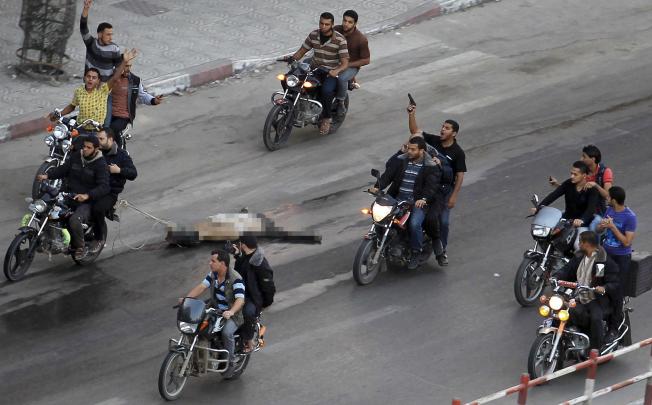 A body is dragged through the streets of Gaza City. The dead man had been a suspected collaborator with Israel. Photo: Reuters
