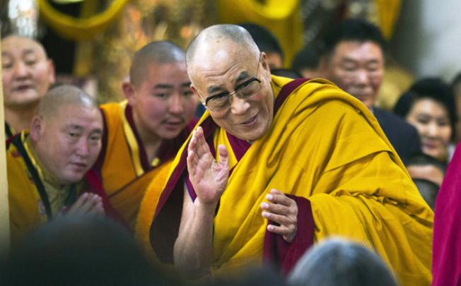 Tibetan spiritual leader the Dalai Lama greets devotees as he arrives to give a religious talk at the Tsuglakhang temple in Dharmsala, India, on Tuesday. Photo: AP