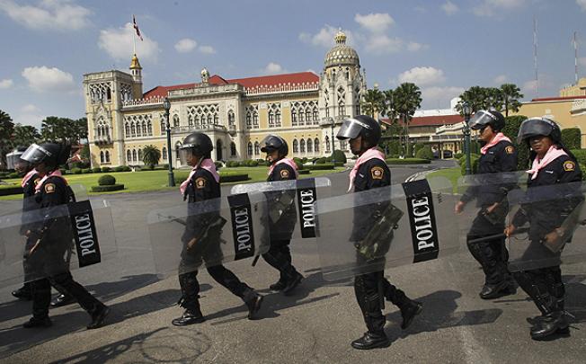 Thai policemen patrol inside the compound of Government House in Bangkok on Friday. Photo: AP