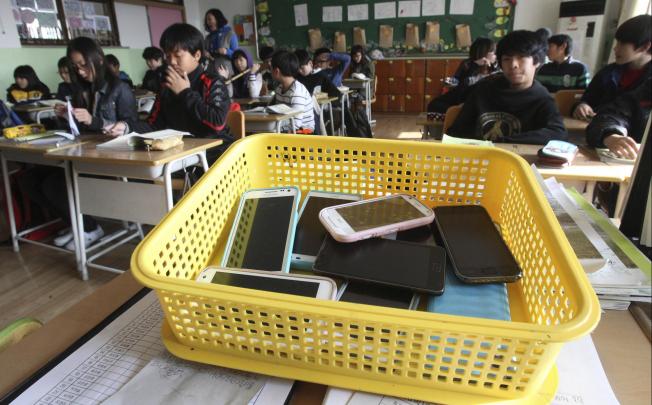 Children deposit their smartphones before a lesson in Suwon, South Korea. Photo: AP