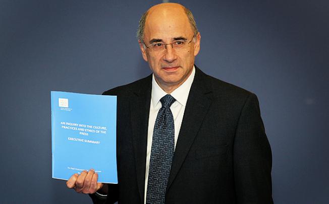 Lord Justice Brian Leveson  poses for photographers as he delivers his report 'Inquiry into the Culture, Practices and Ethics of the Press' in London on Thursday. Photo: AP
