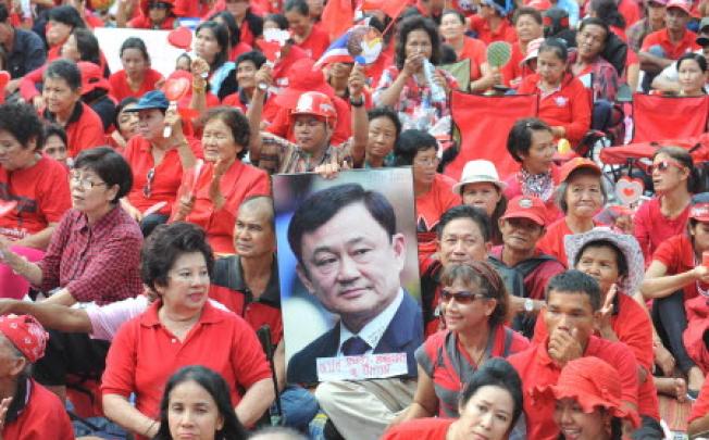 "Red shirt" supporters hold a picture of former premier Thaksin Shinawatra during a rally in Bangkok. Photo: Xinhua