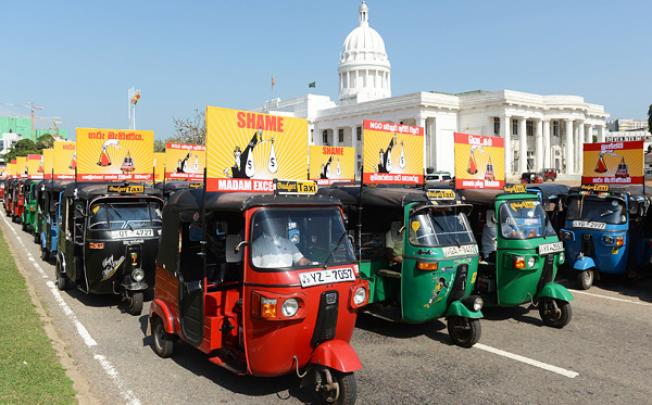 Sri Lankan rickshaw drivers travel past The Town Hall in Colombo on Friday in one of the biggest public displays of protest against the country's chief justice Shirani Bandaranayake who is facing impeachment. Photo: AFP
