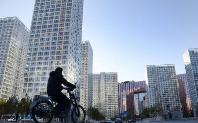 A man rides an electric bike along a street in the central business district in Beijing on November 30, 2012. Photo: AFP