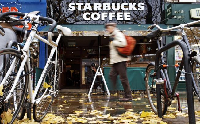 A man walks past a branch of the American coffee chain Starbucks in London. Executive officers of multinational companies Starbucks, Google and Amazon are facing allegations related to tax payments in the United Kingdom. Photo: EPA