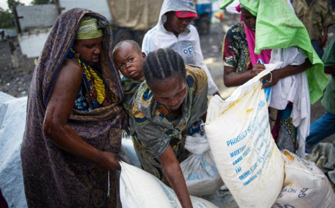 A group of internally displaced Congolese collect food aid in the rain at the Mugunga III IDP camp in the east of the Democratic Republic of the Congo on Sunday. Photo: AFP