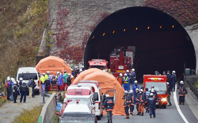 Fire fighters and rescue personnel are seen at the entrance of the Sasago tunnel, about 80km west of Tokyo, in Otsuki, Yamanashi Prefecture, on Monday. Photo: EPA