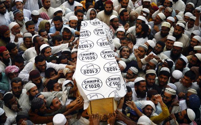 Pakistani Islamic seminary students carry the coffin of cleric Mufti Ismail, who was killed by gumen, during his funeral in Karachi. Photo: AFP