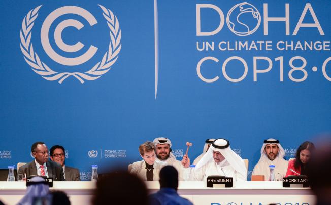President of the conference, Abdullah bin Hamad al Attiyah (second from right, front) announces the final agreements of the UN Climate Change Conference. Photo: Xinhua