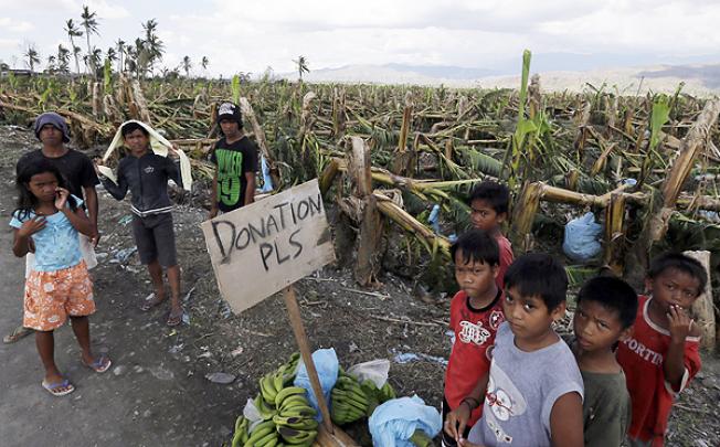 Residents affected by Typhoon Bopha beg for aid from passing motorists along a highway at Montevista township, southern Philippines, on Sunday. Photo: AP