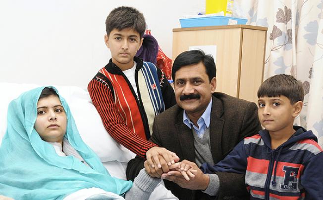 Ziauddin Yousafzai is seen with Malala and her two younger brothers Khushal Khan and Atal Khan (right) at The Queen Elizabeth Hospital in October. Photo: Reuters