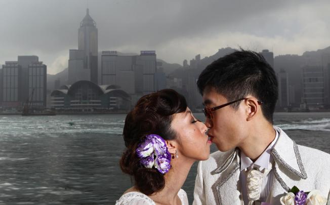 Ling Tsang (left) and Kit Wong seal their union with a kiss in Tsim Sha Tsui. Photo: Nora Tam