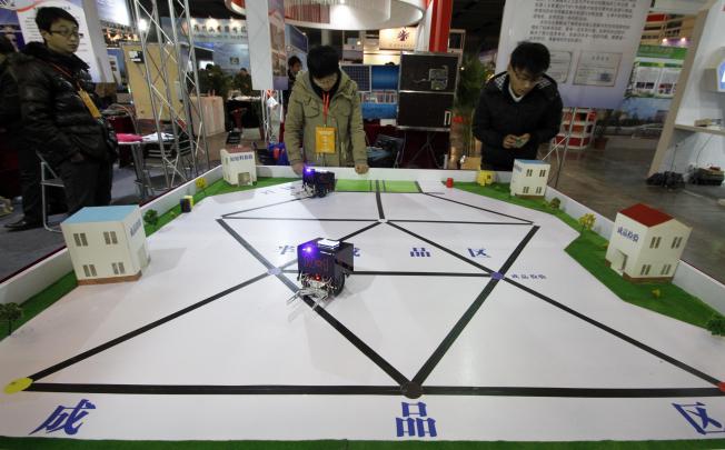 College students show the skills of intelligent robots to convey objects during an exhibition on science, technology and innovation projects in Nanjing. Photo: Xinhua
