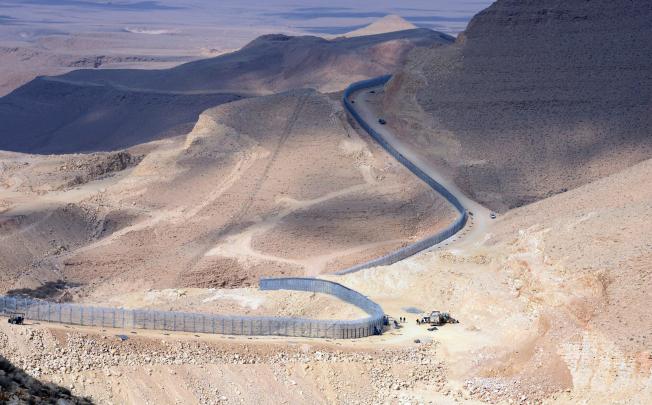 A section of the border fence Israel has erected along its border with Egypt (left). Photo: EPA