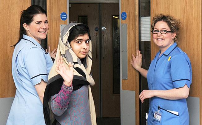 Pakistani schoolgirl Malala Yousufzai waves with nurses as she is discharged from The Queen Elizabeth Hospital in Birmingham. Photo: Reuters