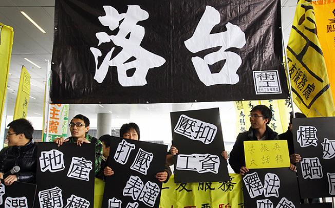 Protestors from Neighbourhood Worker's Service Centre demand Chief Executive Leung Chun-ying to step down. Photo: May Tse