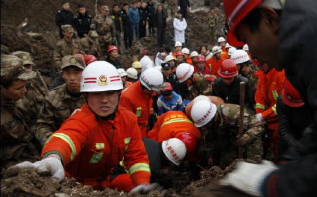 Rescuers work at the mud-inundated debris after a landslide hit Zhaojiagou in Yunnan. Photo: AP