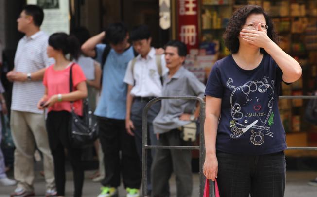 People cover their noses on a street in Mong Kok as the air pollution index of the roadside air monitoring station reached 175. Photo: Nora Tam