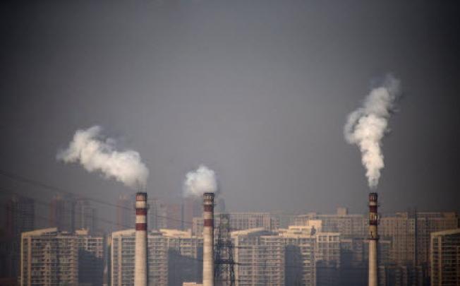 Smoking chimneys in front of residential buildings in Tianjin. The high level of pollution has prompted Li Keqiang to call for stricter enforcement of environmental protections. Photo: Reuters