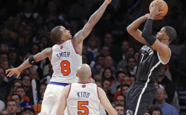 Brooklyn Nets guard Joe Johnson (R) shoots a three-point shot over New York Knicks guards J.R. Smith (8) and Jason Kidd (5) at Madison Square Garden in New York. Photo: Reuters
