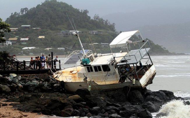 A boat washed up onto rocks in Queensland. Photo: Reuters
